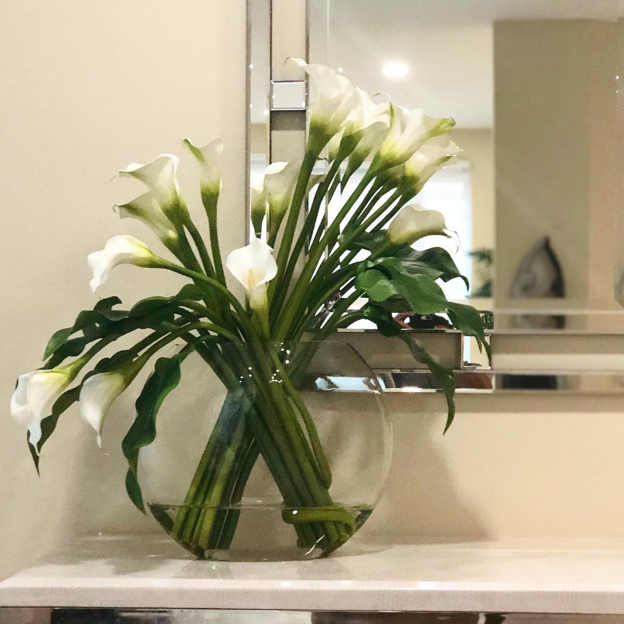 Moon vase with white calla lilies