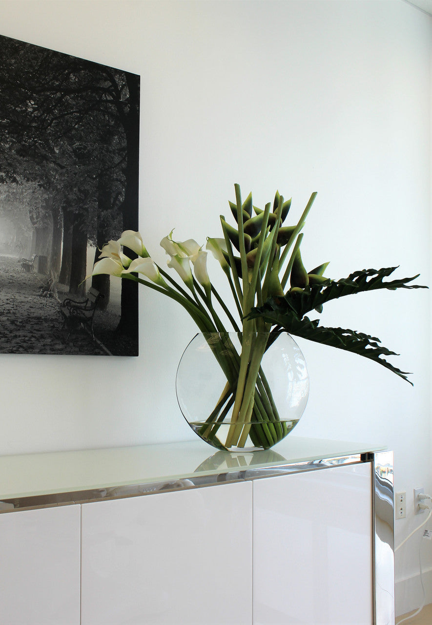 Moon vase with green Heliconias and Calla lilies